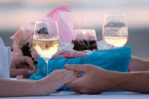 Andaman Lanta Resort - SHA Extra Plus في كو لانتا: مجموعة من الناس يجلسون على طاولة مع كؤوس النبيذ