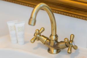 a brass sink faucet in front of a mirror at Zwierzyńscy Residence 2 in Pobierowo +56 photos
