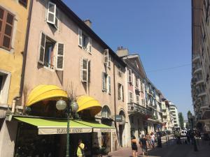 a shop with yellow awnings on a city street at Charmant appartement, centre piéton Vieille Ville Annecy in Annecy