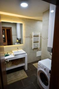 a bathroom with a sink and a washing machine at Apartman Natalija Banja Luka in Banja Luka