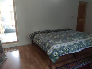 A bed or beds in a room at Chosdup Guest House