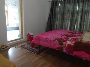 A bed or beds in a room at Chosdup Guest House