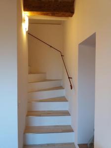 a staircase in a room with white walls and wooden ceilings at CASA GAIA 3 in Portoferraio
