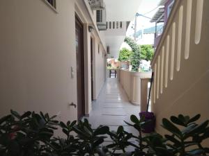 un couloir vide d'un bâtiment avec des plantes dans l'établissement Valentinos House, à Parga