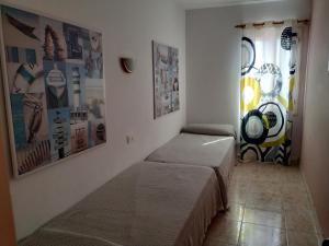 a bedroom with two beds and pictures on the wall at Cala Galdana Beach in Cala Galdana
