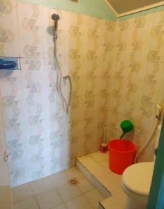 a bathroom with a shower with a toilet and a bucket at Yulia Resort in Sabong