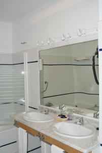 a bathroom with two sinks and a mirror at Gran Hotel Balneario in Baños de Montemayor