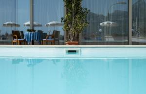 duży basen ze stołem i krzesłami w obiekcie Hotel Panoramic w mieście Giardini Naxos