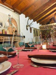 a table with wine glasses on a red table cloth at Complejo El Romeral in Villanueva de los Infantes