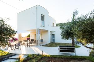 a white house with a courtyard with tables and chairs at Scissure Sea Suite in Gaeta