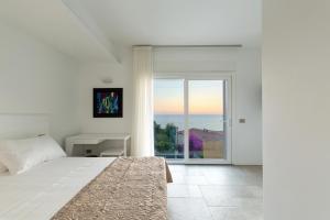a white bedroom with a bed and a window at Scissure Sea Suite in Gaeta