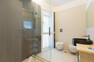 een badkamer met een glazen douche en een toilet bij Scissure Sea Suite in Gaeta