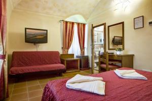 sypialnia z 2 łóżkami, kanapą i lustrem w obiekcie Hotel Residence Villa Rioddi w mieście Volterra +37 zdjęć