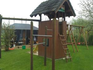 um parque infantil de madeira com uma escada e um escorrega em Ferienhof Schattmann em Sonsbeck