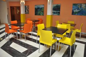 a dining room with tables and yellow chairs at City Central De Luxe in Prague