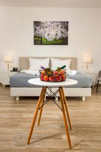 a table with a bowl of fruit on it next to a bed at Blue Sea Hotel in Kanali