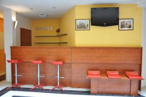 a waiting room with red stools and a flat screen tv at City Central De Luxe in Prague