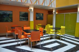 a restaurant with orange and yellow chairs and tables at City Central De Luxe in Prague