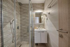 un bagno con lavandino e doccia di Hotel Obala a Dobra Voda