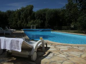 a swimming pool with a chair and a towel on it at Charming Chalet with Swimming Pool in Quend in Quend