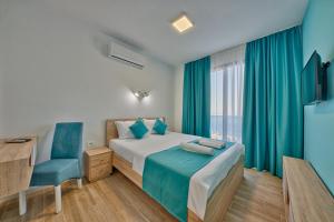 una camera da letto con un letto, una sedia e una finestra di Hotel Obala a Dobra Voda