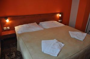 a bedroom with a bed with two white towels on it at City Central De Luxe in Prague