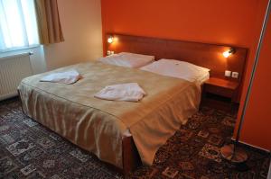 a bedroom with a large bed with two towels on it at City Central De Luxe in Prague