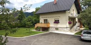 ein weißes Haus mit einem Balkon und einer Auffahrt in der Unterkunft Green Garden Apartment in Bled