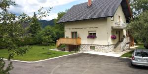 a white house with a balcony and a driveway at Green Garden Apartment in Bled