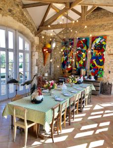uma sala de jantar com uma mesa longa e cadeiras em Chateau De La Goujonnerie em Loge-Fougereuse