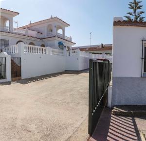 uma cerca branca em frente a uma casa em Chalet en Matalascañas a 300 metros de la playa em Matalascañas