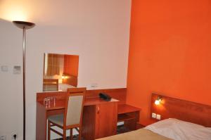 a bedroom with a desk and a bed and a mirror at City Central De Luxe in Prague