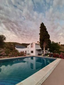 uma piscina em frente a uma casa branca em La Fuente Retreat em Lecrin