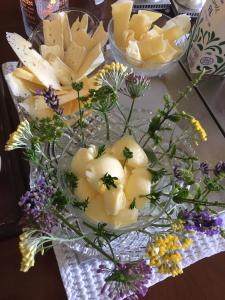 eine Glasvase mit Käse und Blumen auf dem Tisch in der Unterkunft Wiroth B&B Hannasvägen 41, Eget badrum, Aircondition in Hammenhög