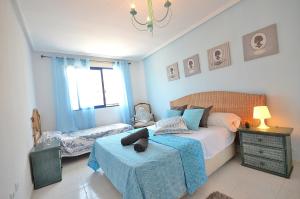 um quarto com uma cama com um cobertor azul em Sweet Home BellaVista em Torrevieja