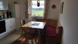 een keuken met een tafel en stoelen en een raam bij Hauserwirt in Wildsteig