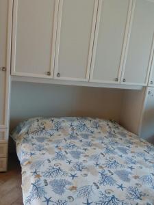 Bett in einem Zimmer mit weißen Schränken in der Unterkunft SEA VIEW HOUSE SARDEGNA in Badesi