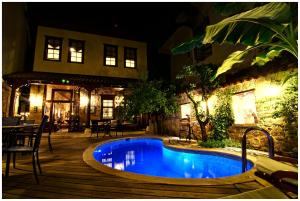 a swimming pool in front of a house at night at Minyon Hotel in Antalya