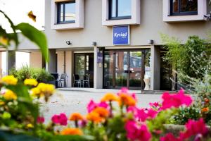 a building with flowers in front of it at Kyriad Hotel Strasbourg Lingolsheim in Lingolsheim