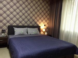 um quarto com uma cama com um edredão azul em Westend Hotel Kyiv em Kiev