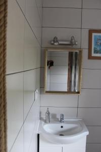 La salle de bains blanche est pourvue d'un lavabo et d'un miroir. dans l'établissement Karpacka Chata, à Rymanów-Zdrój