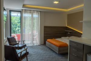 una camera da letto con un letto, una sedia e una finestra di Spa & wellness Villa Garetov Konak a Prolomska Banja