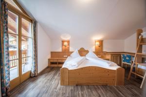 Schlafzimmer mit einem Bett, einem Schreibtisch und einem Fenster in der Unterkunft Hotel Rosenheim in Ratschings