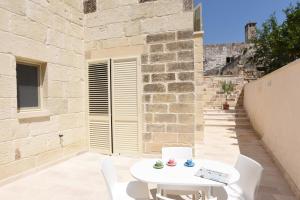 a patio with a white table and white chairs at Agorà in Zollino