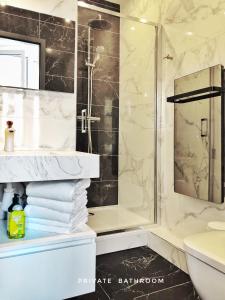 a bathroom with a shower and a stack of towels at LIFE CATHEDRALE City-Center Place Gutenberg in Strasbourg