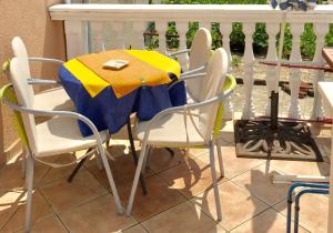 a table and chairs with a yellow and blue table cloth at Apartman Luna Punat in Punat
