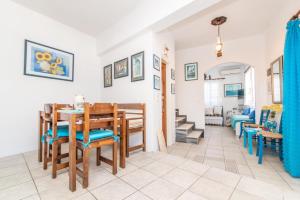a dining room and living room with a table and chairs at Luxury Wave Maisonette in Istérnia