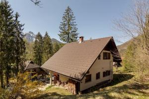 una casa blanca con techo marrón en el bosque en Chalet Mia en Gozd Martuljek