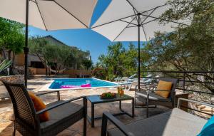 un patio con sillas, una sombrilla y una piscina en Apartment Korina Vela Luka Gradina en Vela Luka