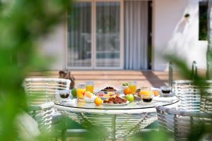 a table with a plate of food and drinks at Alexandra Beach Spa Resort in Potos